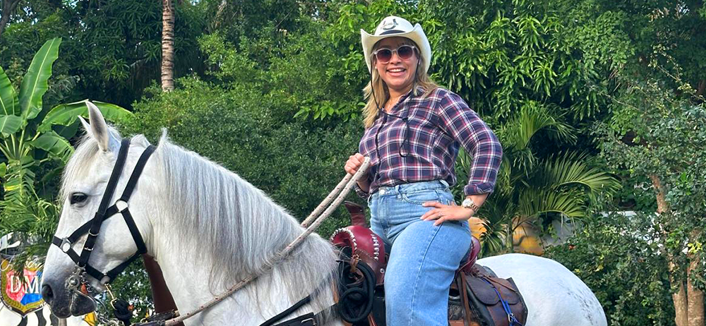 Woman in sunglasses riding a horse