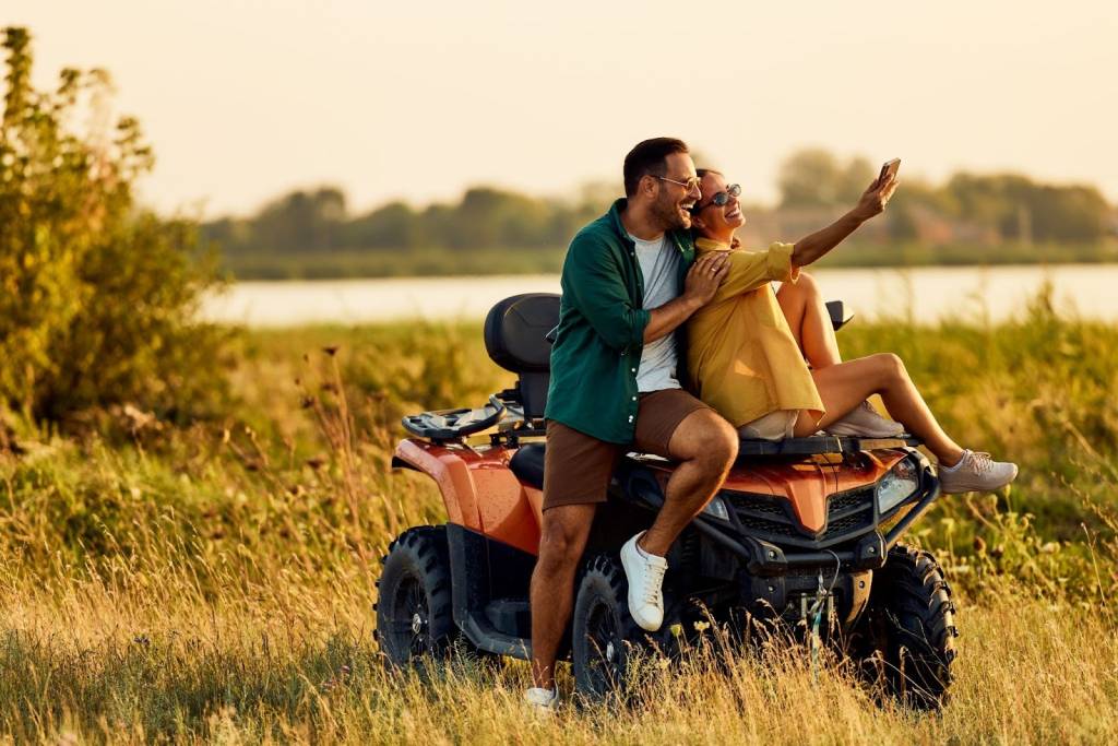 A happy couple is taking a picture together on an ATV.