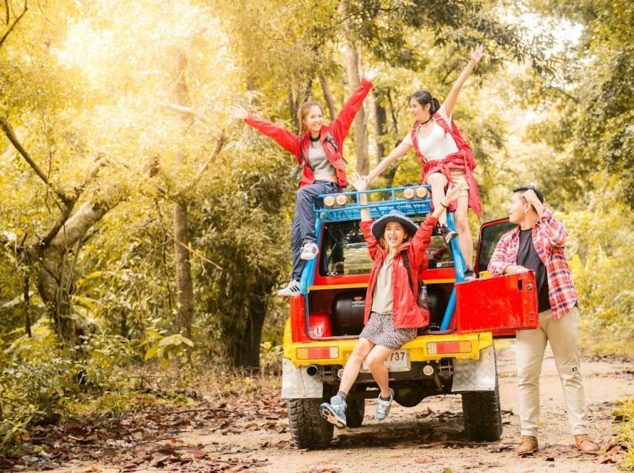 Four friends happily pose on a colorful four-wheeler before heading to the nature trail.