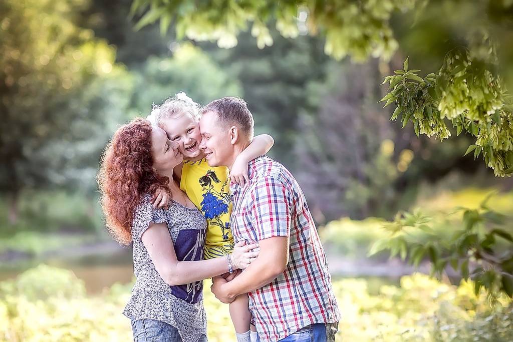 Family photo shoot in a sunny park, capturing joyful togetherness