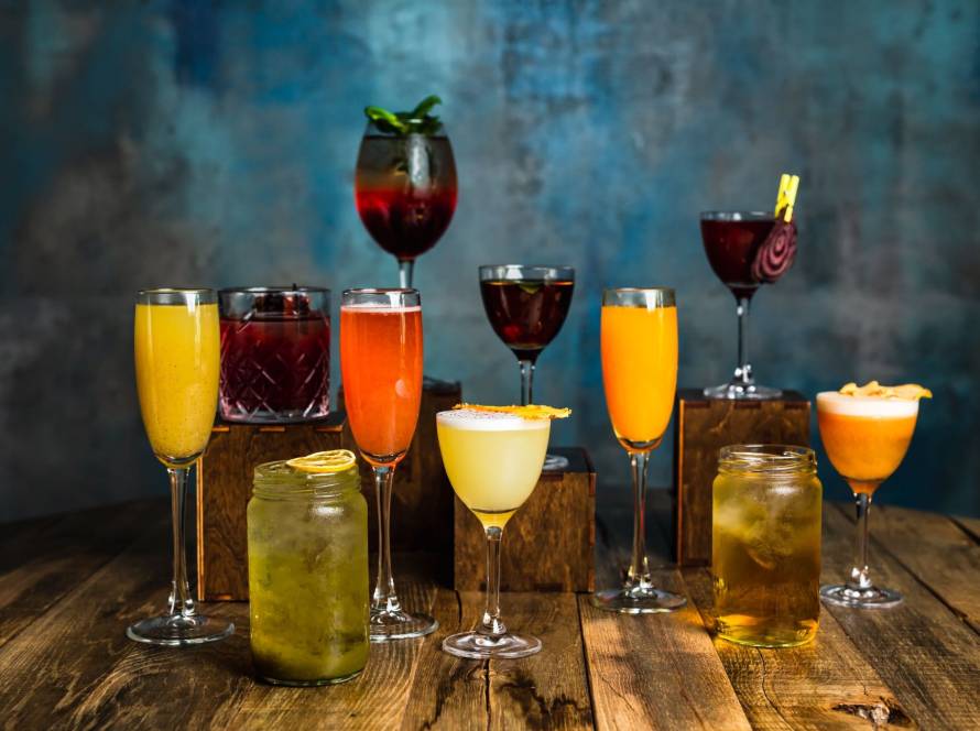 Vibrant assortment of zero-proof cocktails on a rustic wooden table, featuring colorful garnishes and fresh, alcohol-free ingredients